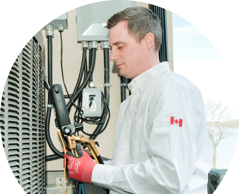 Anchor Home Comfort technician servicing an outdoor air conditioner using a digital refrigerant tool, wearing red gloves and a white uniform. Anchor Home Comfort technician servicing an outdoor air conditioner using a digital refrigerant tool, wearing red gloves and a white uniform.