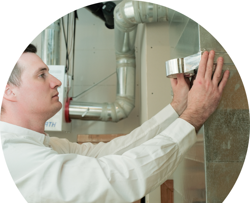 A Anchor Home Comfort HVAC personnel securing air ducting with foil tape during an air duct installation in a residential utility space with visible metal ventilation lines. A Anchor Home Comfort HVAC personnel securing air ducting with foil tape during an air duct installation in a residential utility space with visible metal ventilation lines.