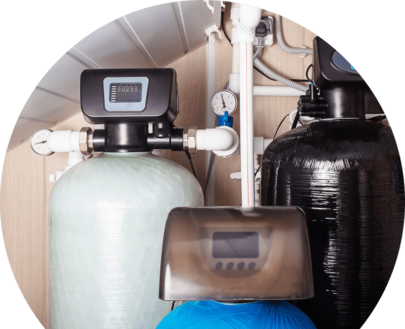 Anchor Home Comfort home water filtration system featuring resin tanks, digital control heads, pressure gauges, and connected piping in a utility room. Anchor Home Comfort home water filtration system featuring resin tanks, digital control heads, pressure gauges, and connected piping in a utility room.