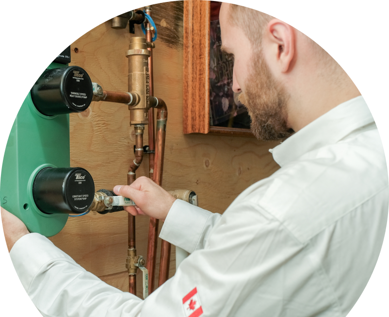 Anchor Home Comfort HVAC specialist performing boiler installation, securing a valve on a new hydronic heating system with copper piping and a green circulation pump mounted on a wooden wall. Anchor Home Comfort HVAC specialist performing boiler installation, securing a valve on a new hydronic heating system with copper piping and a green circulation pump mounted on a wooden wall.