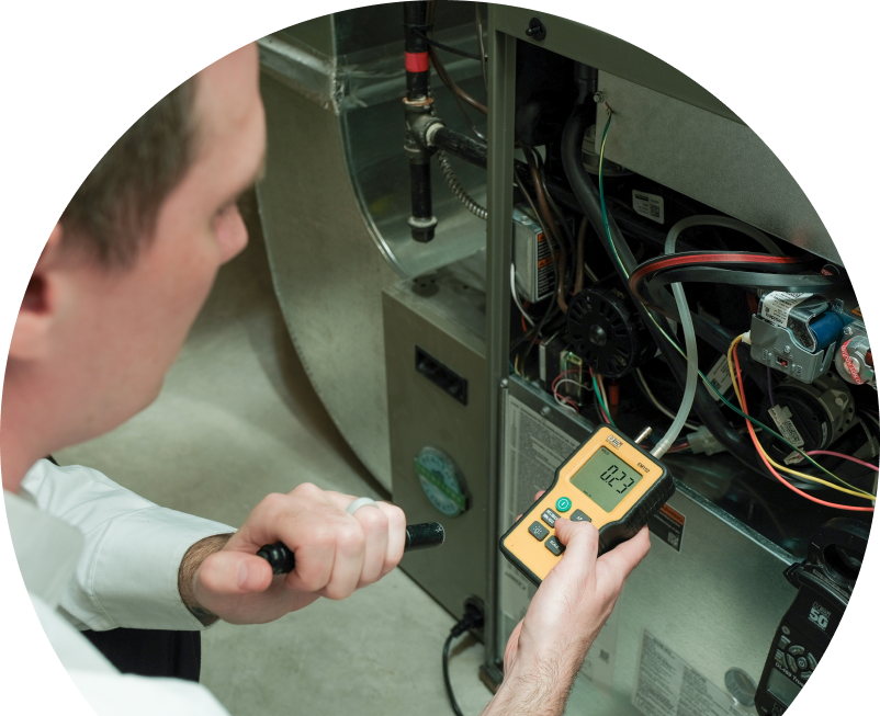 Anchor Home Comfort HVAC specialist performing furnace repair on a heating system, using a digital manometer to check pressure. Anchor Home Comfort HVAC specialist performing furnace repair on a heating sy