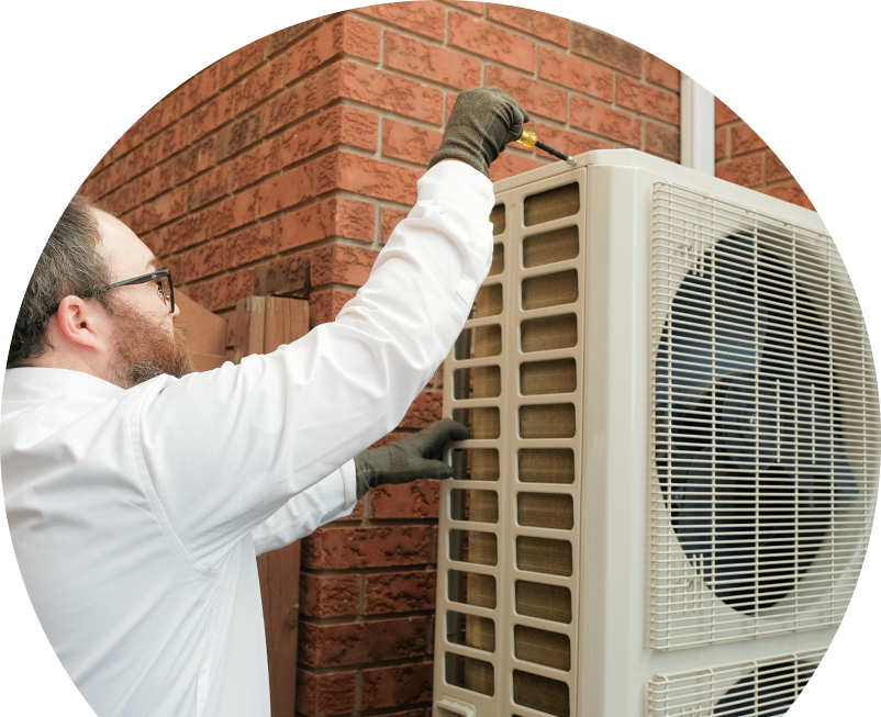 Anchor Home Comfort HVAC specialist using a screwdriver to complete a heat pump installation beside a brick wall. Anchor Home Comfort HVAC specialist using a screwdriver to complete a heat pump installation beside a brick wall.